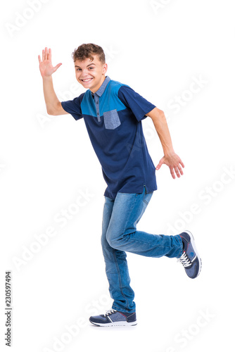 Full length portrait of young caucasian teen boy isolated on white background. Funny teenager walking. Handsome active child running, looking at camera and smiling.