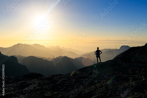 Woman hiking success silhouette in mountains sunset