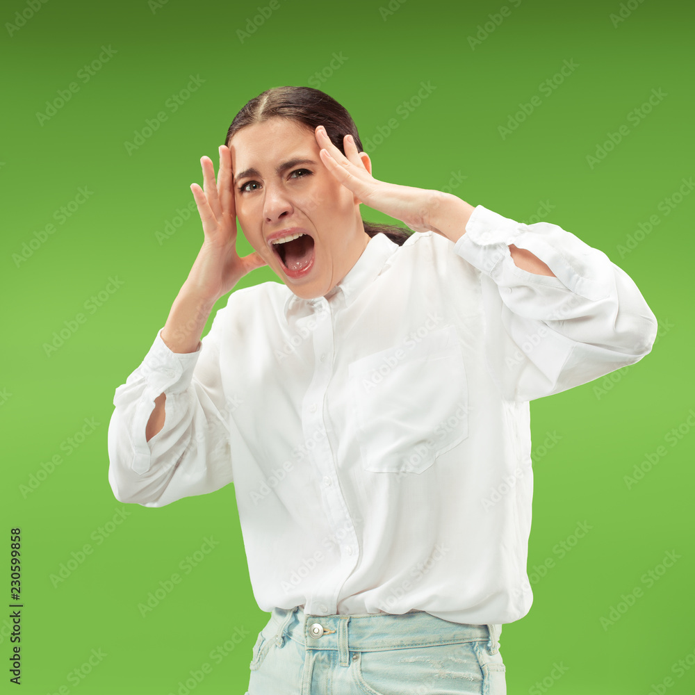 Screaming, hate, rage. Crying emotional angry woman screaming on green studio background. Emotional, young face. Female half-length portrait. Human emotions, facial expression concept. Trendy colors Screaming, hate, rage. Crying emotional angry woman screaming on green studio background. Emotional, young face. Female half-length portrait. Human emotions, facial expression concept. Trendy colors