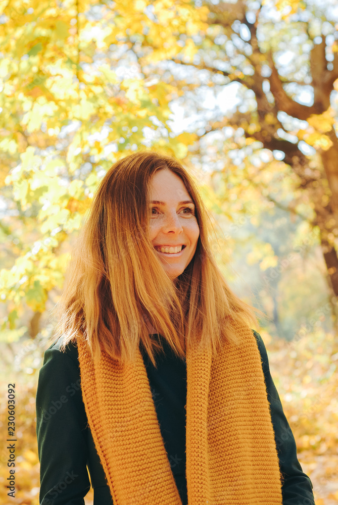 Gorgeous red head girl in dress and orange scarf. Young woman posing in autumn park. Gorgeous red head girl in dress and orange scarf. Young woman posing in autumn park.
