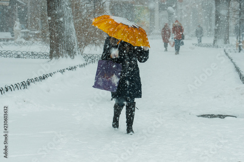 Fototapeta Naklejka Na Ścianę i Meble -  Winter. Man under an umbrella in snowy weather. Bad weather concept