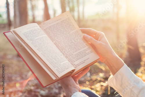 Attractive woman is reading book in nature