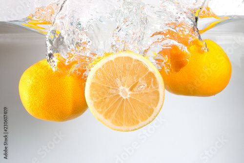 Fototapeta Naklejka Na Ścianę i Meble -  Three orange in water splash on white