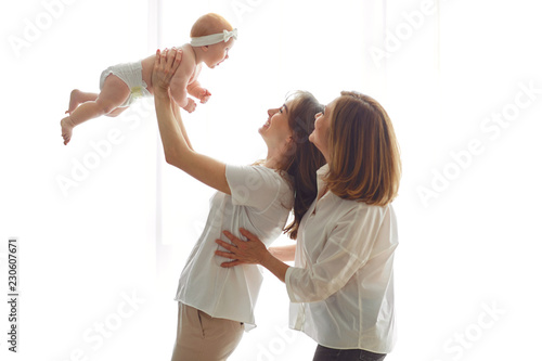 Mother, grandmother and toddler on hands on a white background. A family.