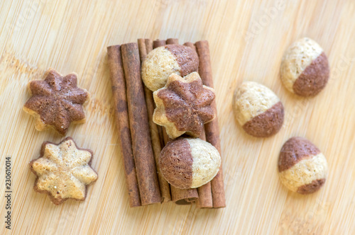 Cinnamon sandbakelse christmas cookies, two colors, cocoa dark brown and vanilla light golden brown, cinnamon raw bark spice photo