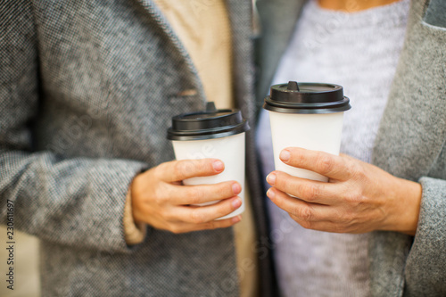 Hands with cups of coffee to go.