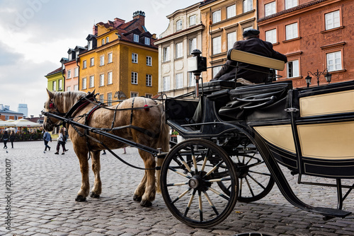 A man with a traditional carriage waits for tourists in the old town of Warsaw, Poland.