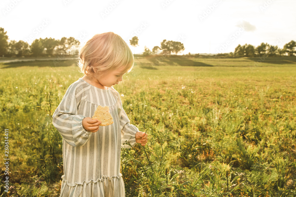 Little girl eating in the field
