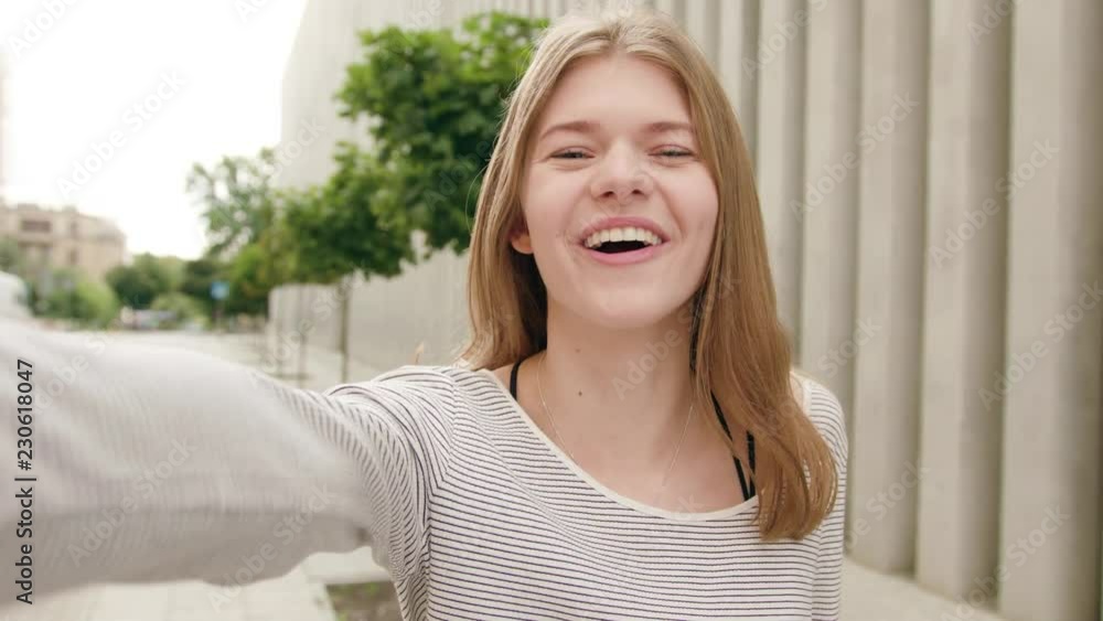 An attractive young lady making a video call in town. Medium shot. Soft focus An attractive young lady making a video call in town. Medium shot. Soft focus