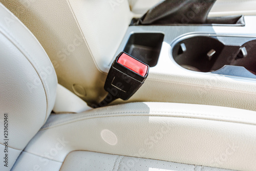 cropped image of leather car seats and retractable platform of seatbelt