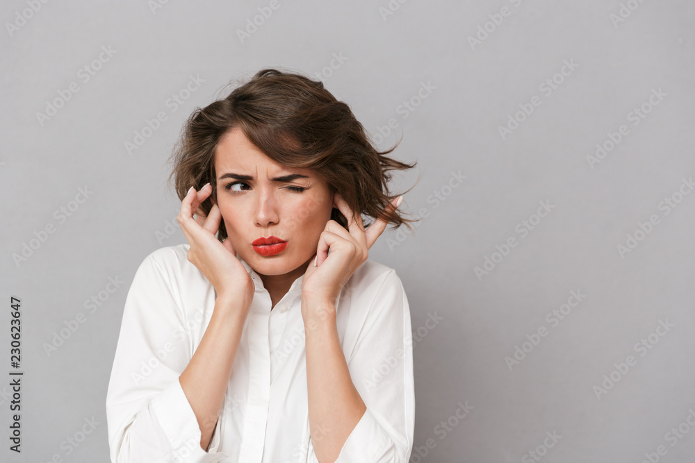 Portrait of an irritated young woman dressed in white Portrait of an irritated young woman dressed in white