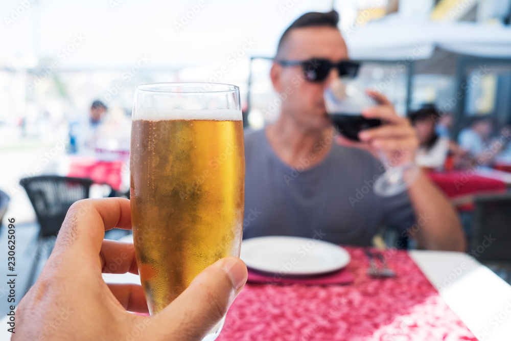 two men drinking beer and wine in a restaurant two men drinking beer and wine in a restaurant