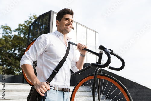Fotografía Confident businessman dressed in shirt carrying a bicycle