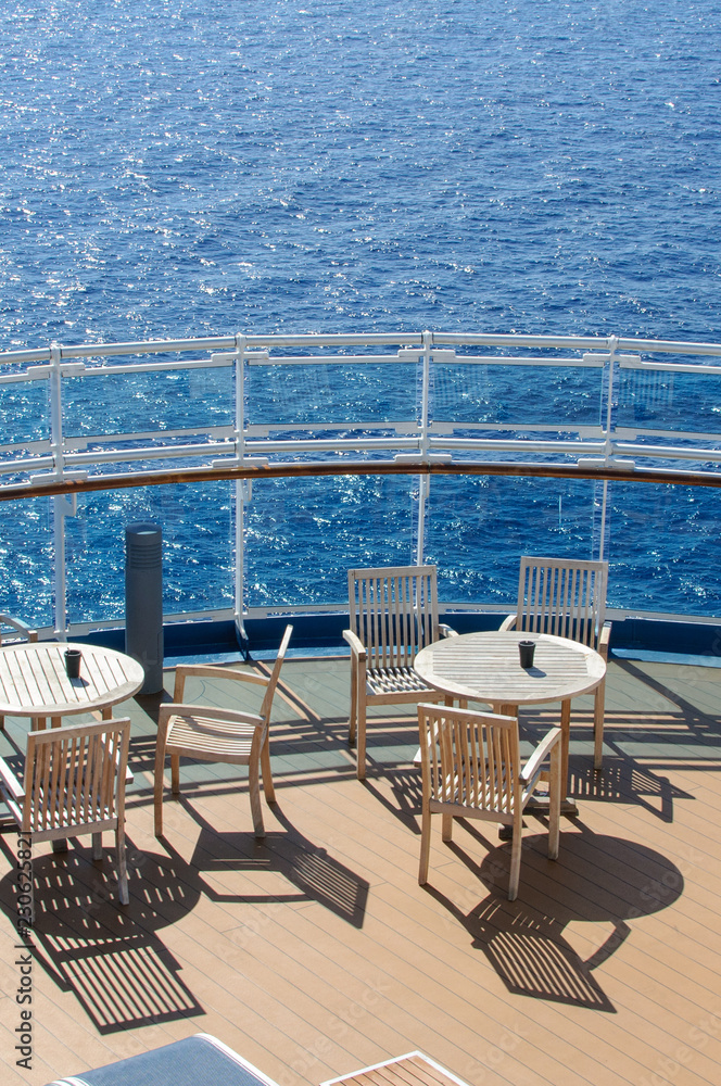Obraz premium View from the deck of a cruise ship in the ocean. Seating area for passengers, chairs and sun loungers. Sunbathe.