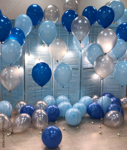 A beautiful room decorated with helium balloons of blue, light blue and silvery colors. Professional design.