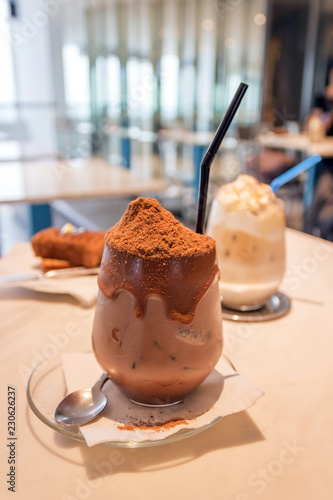 Glass of iced chocolate on marble table at minimalist café photo