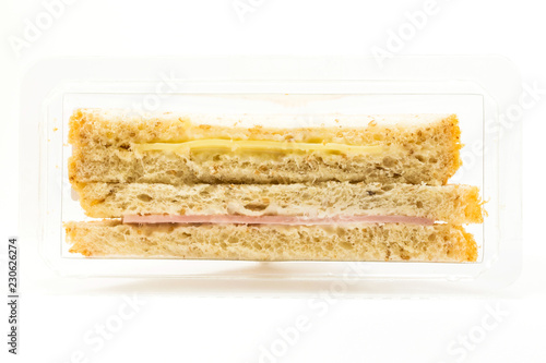 Whole wheat sandwich toast with ham and cheese in a plastic box isolated on white background photo