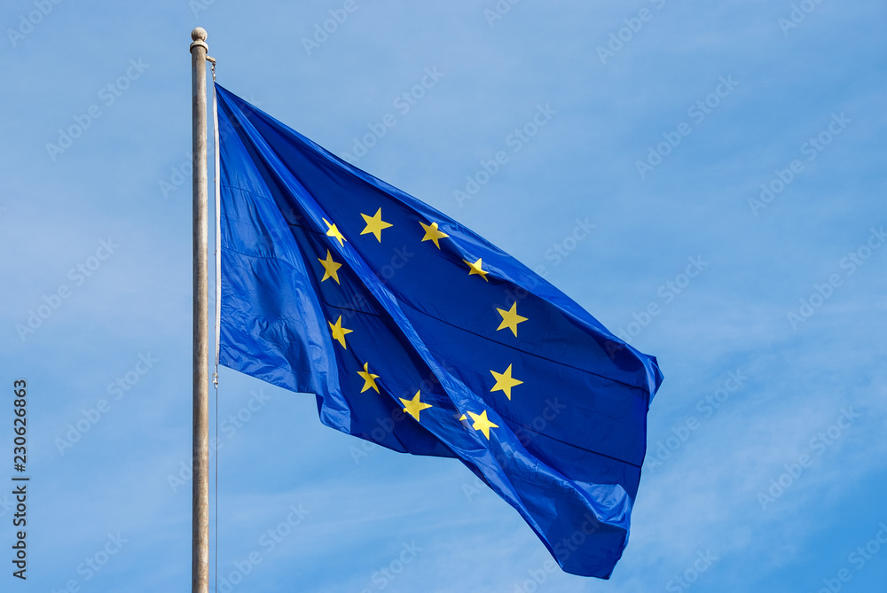 European Union Flag with yellow stars fluttering in the wind