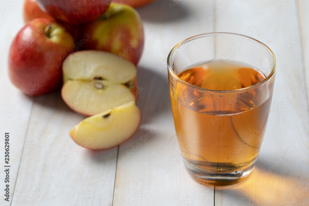 Fresh apple juice in the glass on wooden floor. Fresh apple juice in the glass on wooden floor.