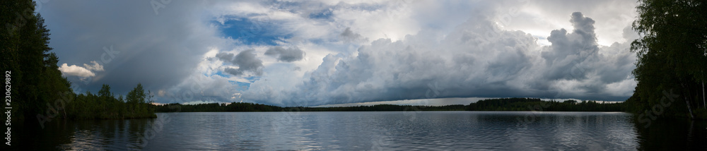 Storm clouds over lake landscape panorama