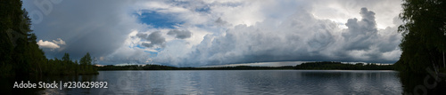 Storm clouds over lake landscape panorama
