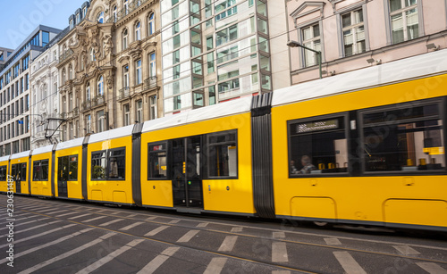 Yellow tram in the city center, office buildings background