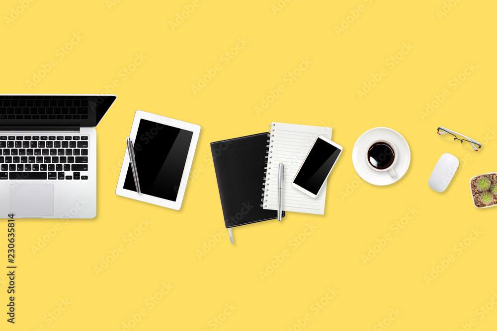 flat lay workspace table with laptop computer, office supplies, coffee cup, tablet and cell phone on yellow pastel background flat lay workspace table with laptop computer, office supplies, coffee cup, tablet and cell phone on yellow pastel background