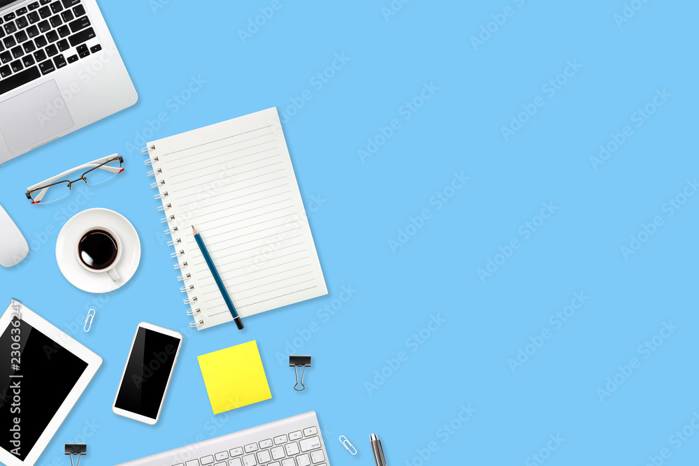 workspace table with laptop computer, office supplies, coffee cup, cell phone and coffee cup on blue pastel background workspace table with laptop computer, office supplies, coffee cup, cell phone and coffee cup on blue pastel background