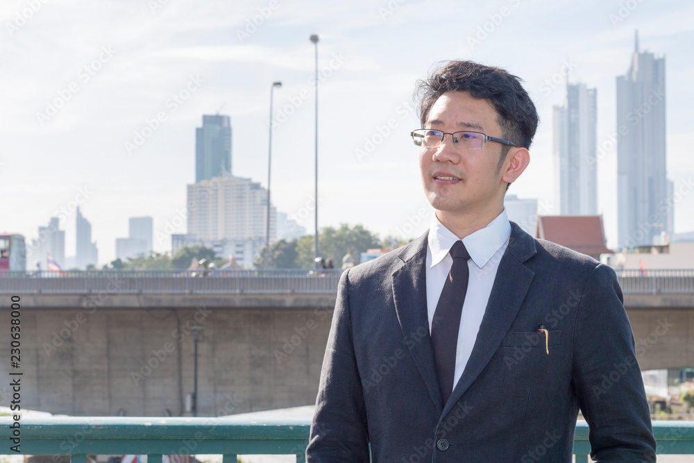 Handsome business maneger man smiling and thinking about success work.Male in black suite and glasses.