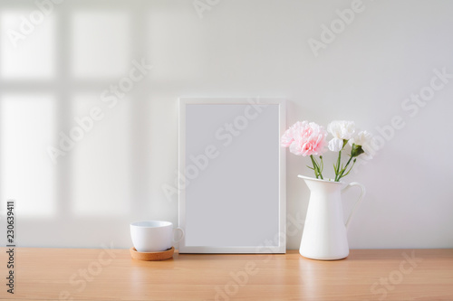 Mock up protrait photo frame with flowers on table