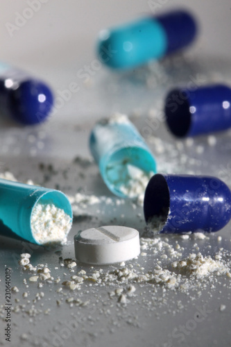 Opened blue pills with white powder close up