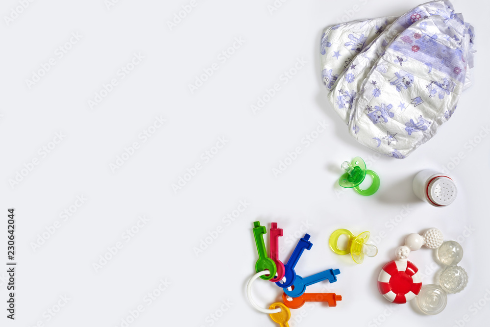 Babies goods diaper, soother or nipple on white background with copy space. Top view or flat lay. Babies goods diaper, soother or nipple on white background with copy space. Top view or flat lay.