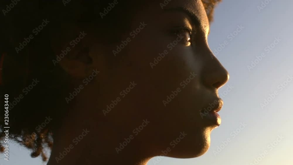Close-up face of beautiful sad woman enjoying sunset, purity and sincerity Close-up face of beautiful sad woman enjoying sunset, purity and sincerity