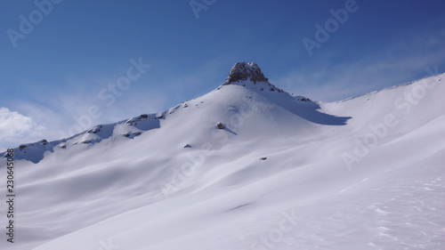 idyllic winter mountain landscape in the Swiss Alps with remote and wild Spitzmeilen peak in the center