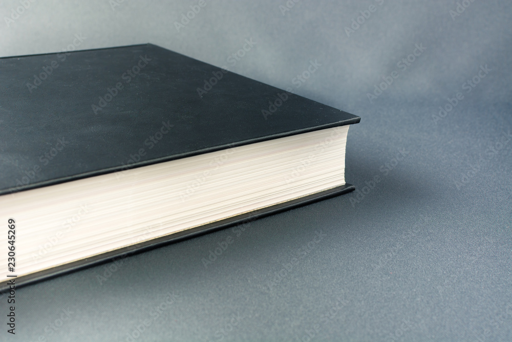 Thick black book on a gray background Thick black book on a gray background
