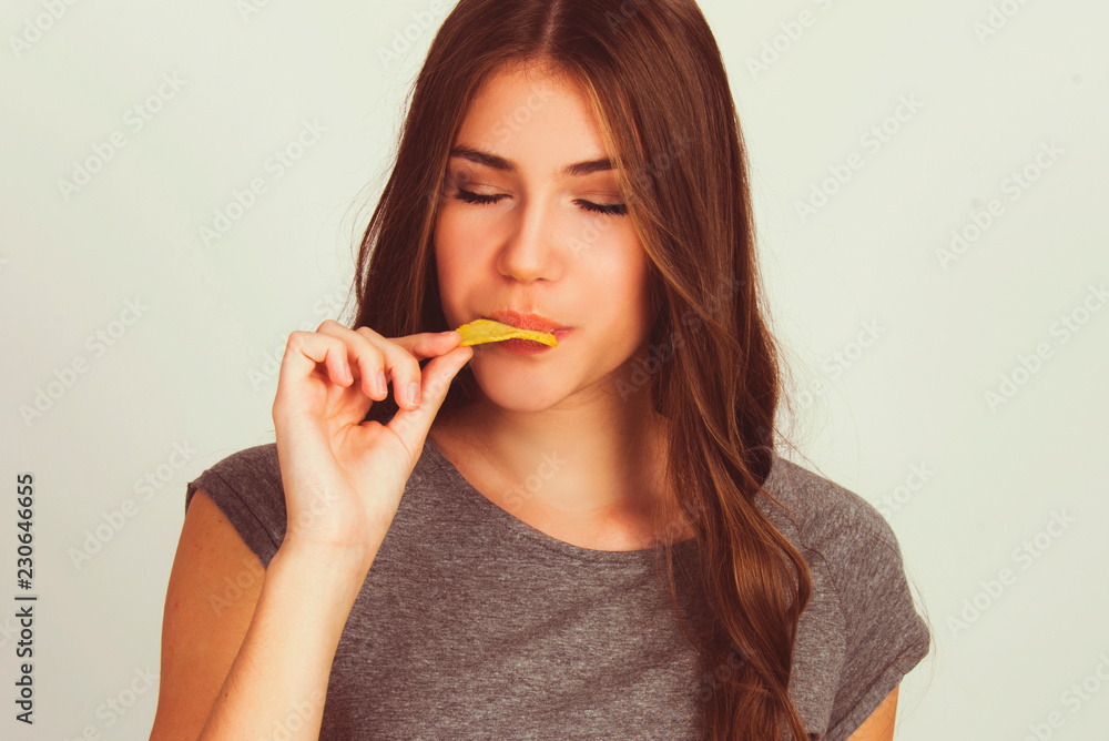 beautiful teen girl eating potato chips isolated on white model Caucasian beautiful teen girl eating potato chips isolated on white model Caucasian