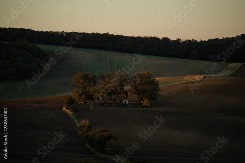 The lone church of St. Barborka in the area of wine called Moravian Tuscany during the autumn sunset around are going to see the fields. Sharp side sun and shadows along with the sky on the horizon.