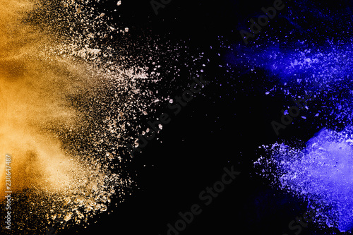 Yellow-blue powder explode cloud on black background. Launched yellow-blue dust particles splash on background.