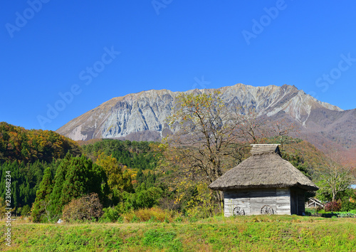 秋の大山と茅葺小屋