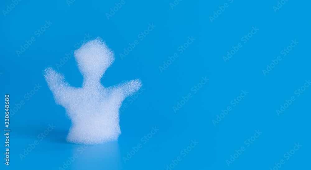Soapy bubbles foam man silhouette on blue background. Suds shower texture macro view photo, shallow depth of field. Copy space.