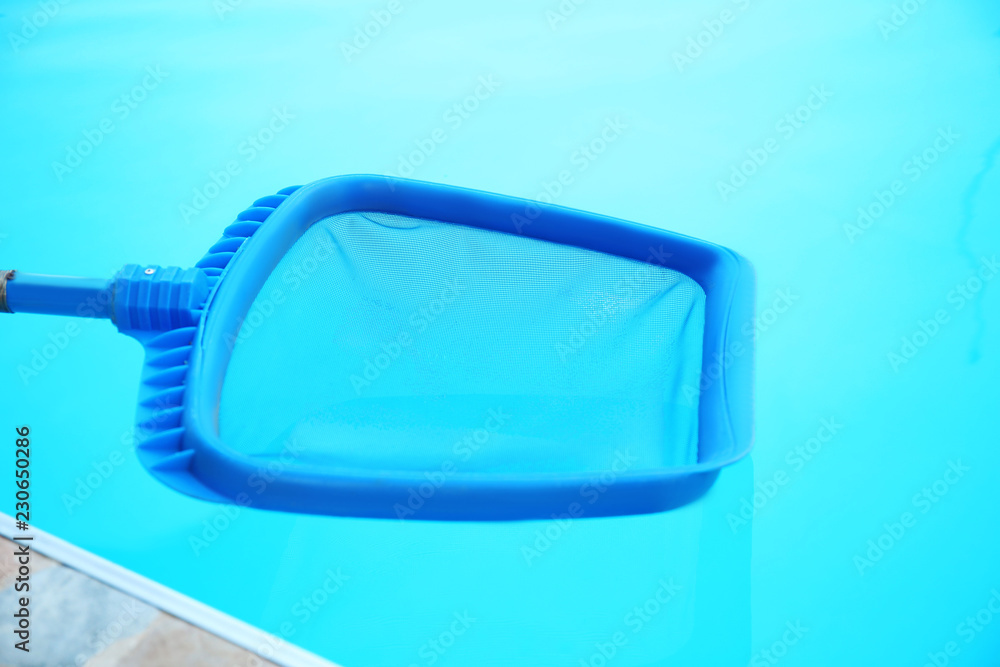 Cleaning outdoor pool with scoop net, closeup