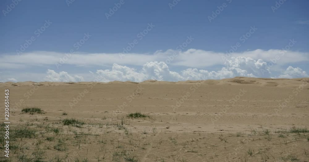 4k great white puffy cloud mass rolling over desert sand dunes. 4k great white puffy cloud mass rolling over desert sand dunes.