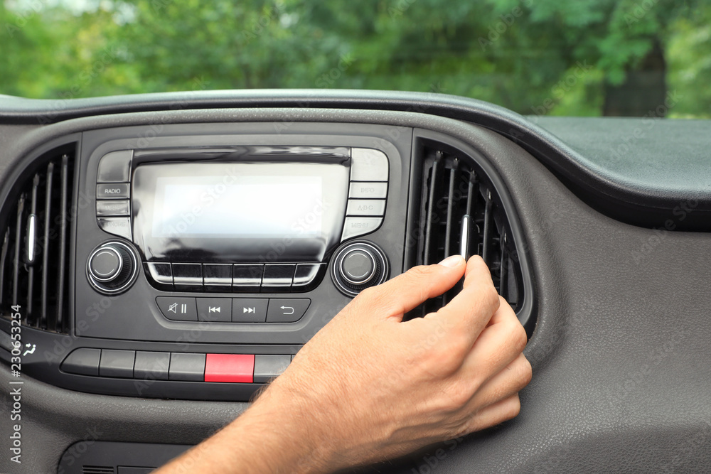 Man adjusting air conditioner in car, closeup Man adjusting air conditioner in car, closeup
