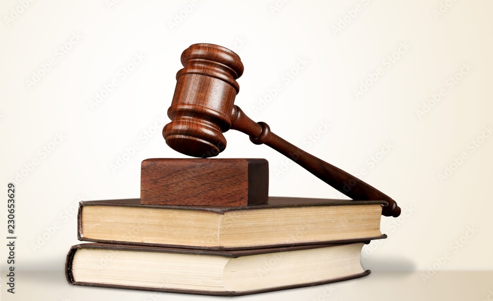 Male hand with wooden judge hammer, shelves Male hand with wooden judge hammer, shelves