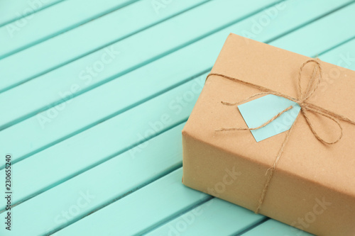 Parcel with tag on wooden background. Space for text