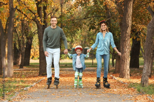 Happy family roller skating in autumn park