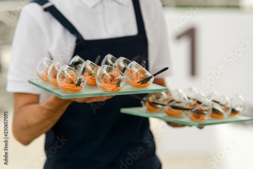 Waiter carrying trays with food