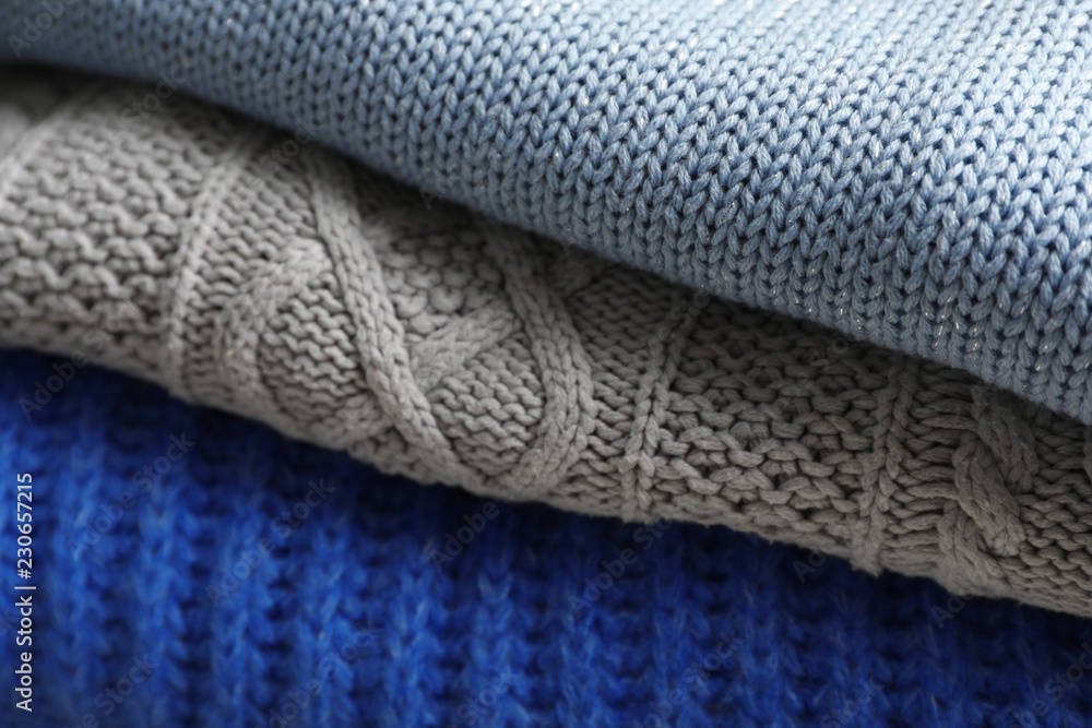 Stack of folded warm knitted sweaters, closeup Stack of folded warm knitted sweaters, closeup