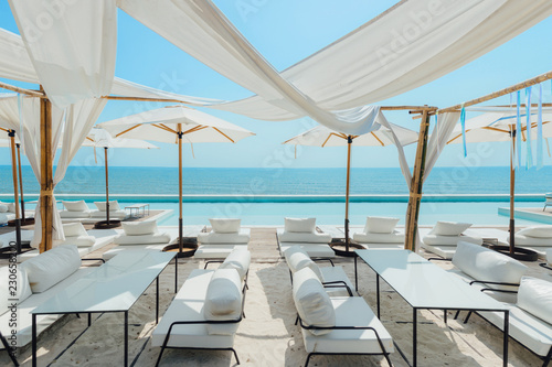 Fototapeta Beautiful luxury swimming pool on sea view and umbrella and chair in hotel resor