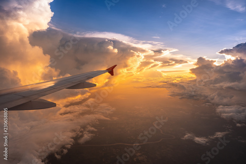 Beautiful sunset with cloudy sky from the airplane window.